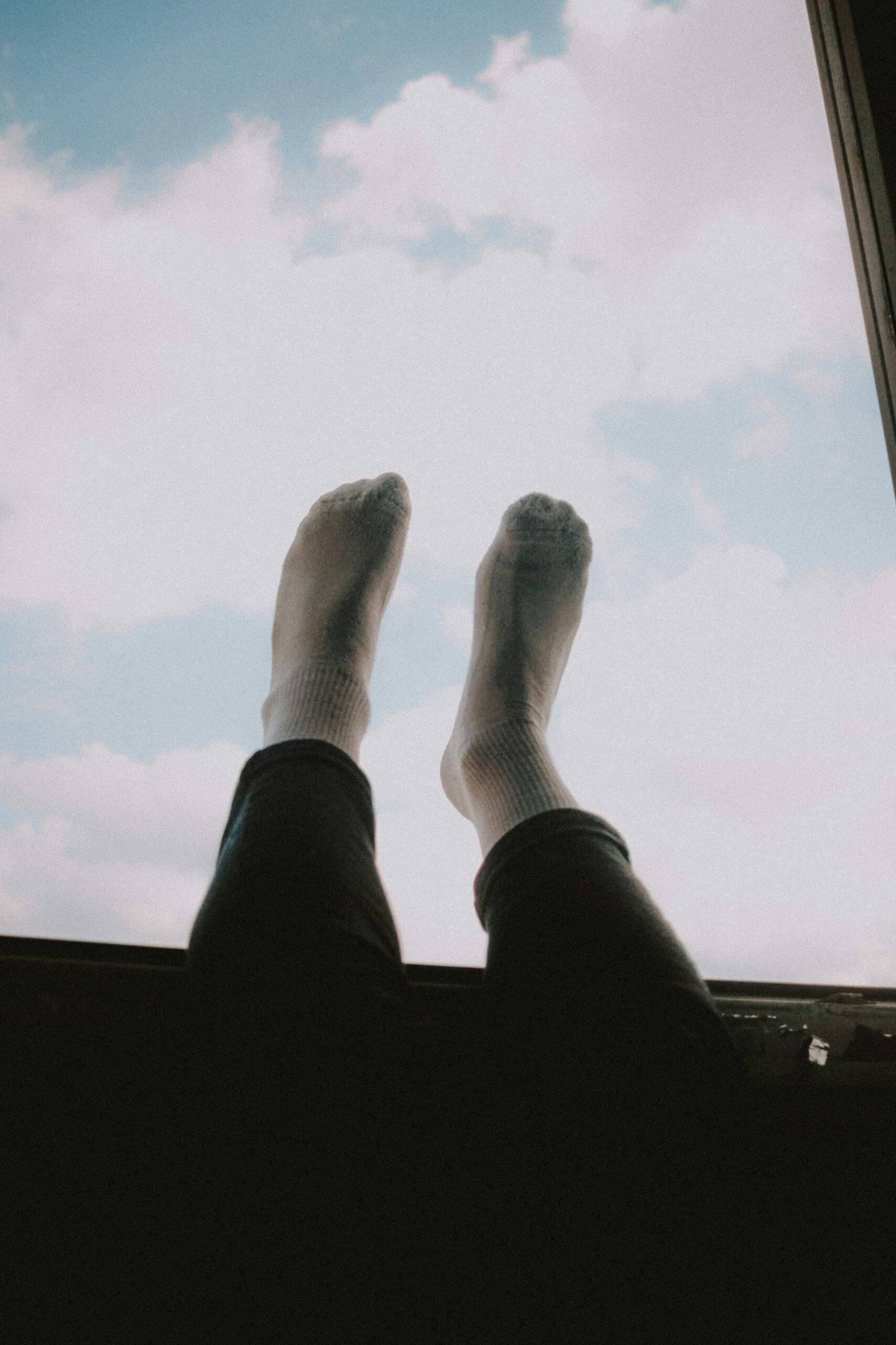 Legs up with socks, sky in background
